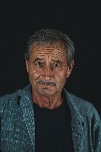 An older man wearing a shirt. What is a surname?  Sometimes they are passed down from fathers to their children. 